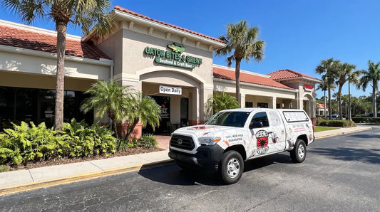 A Webenex Services pest control truck parked outside a commercial shopping center in Clermont, Florida