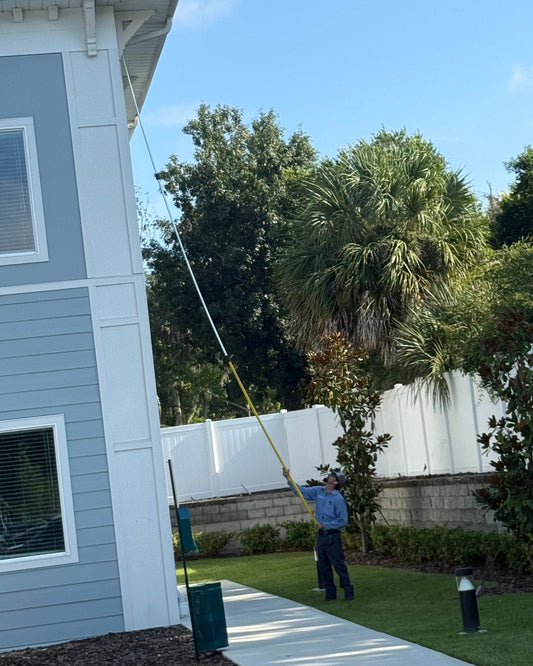 Webenex technician de-webbing the eave of a multi-unit building