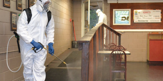 Webenex technicians in protective suits treating a restaurant dining room