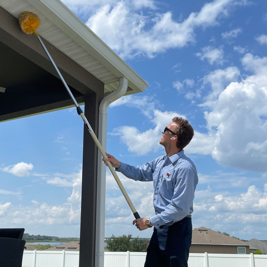 Webenex Services technician removing webs from a home porch in Central Florida