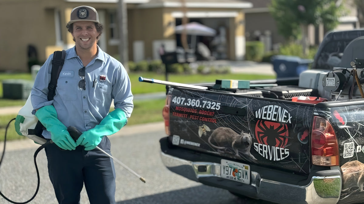Kevin Sukovich, owner of Webenex Services, in uniform beside the company truck at a Clermont, FL home