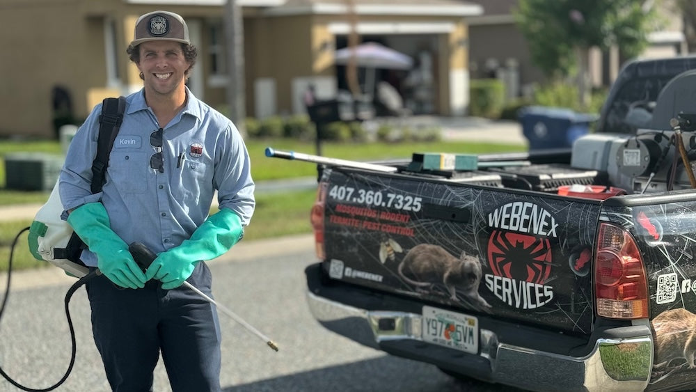 Webenex Services pest control technician with a backpack sprayer beside a Webenex service truck in Clermont, FL